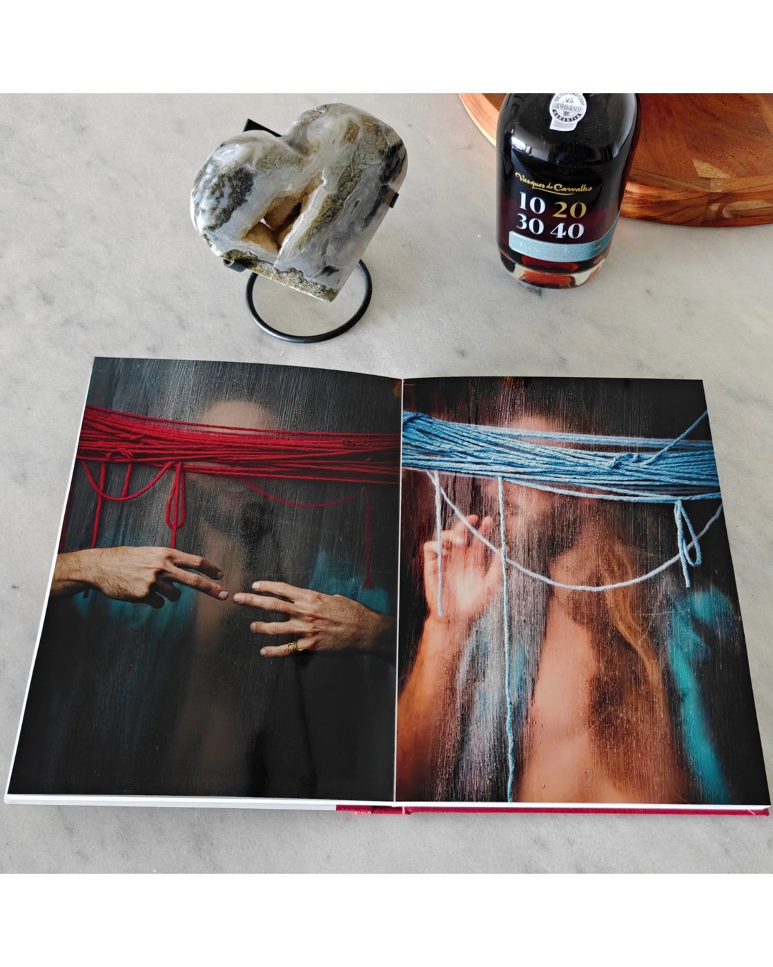 Open NiNE photobook showing red cord portraiture and a nude photograph