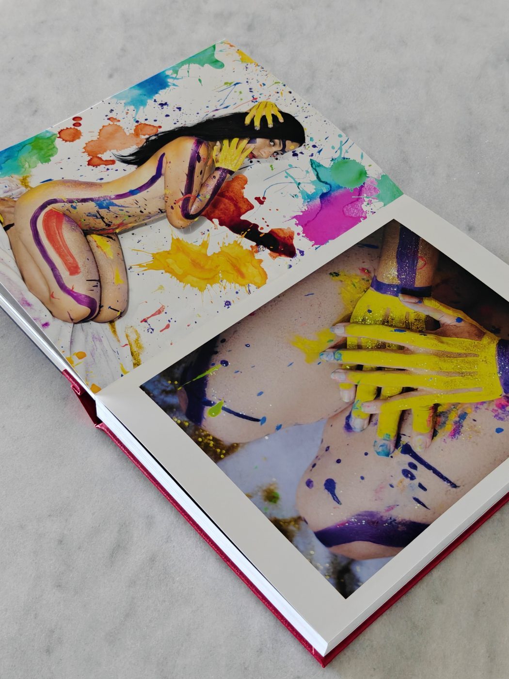 Open NiNE photobook showing colorful painted figures